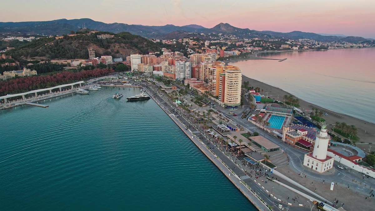 Málaga’s port, lighthouse and the La Malagueta seafront at dusk